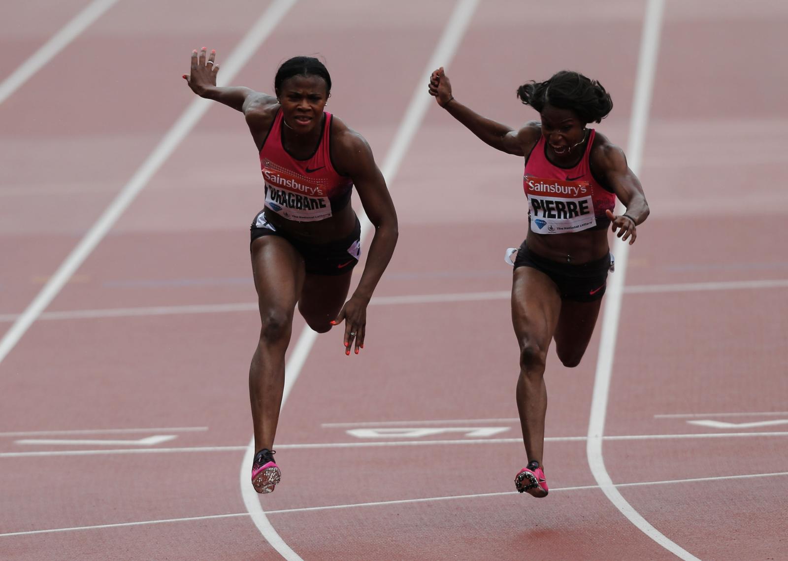 (L-R) Blessing Okagbare of Nigeria crosses the line ahead of Barbara Pierre of the United States in the Women's 100m Final during day two of the Sainsbury's Anniversary Games - IAAF Diamond League 2013 at The Queen Elizabeth Olympic Park on July 27, 2013 in London, England. (Photo by Harry Engels/Getty Images)