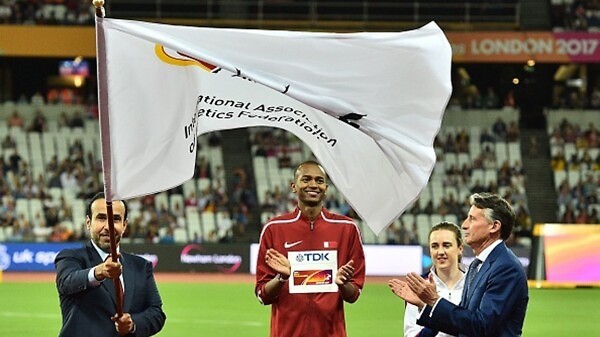 Dr Thani Al Kuwari, President of the QAF, receives IAAF flag from Lord Coe, President IAAF alongside Mutaz Barshim