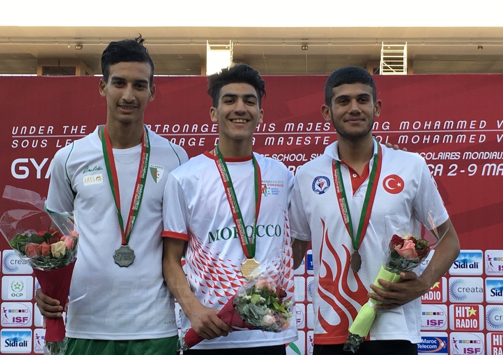 Fouad Messoudi (MAR) Hamdani Benahmed (TUN) and Tarik Demir (TUR) on the podium for Boys 1500m presentation at the Gymnasiade 2018 in Marrakech / Photo Credit: Yomi Omogbeja