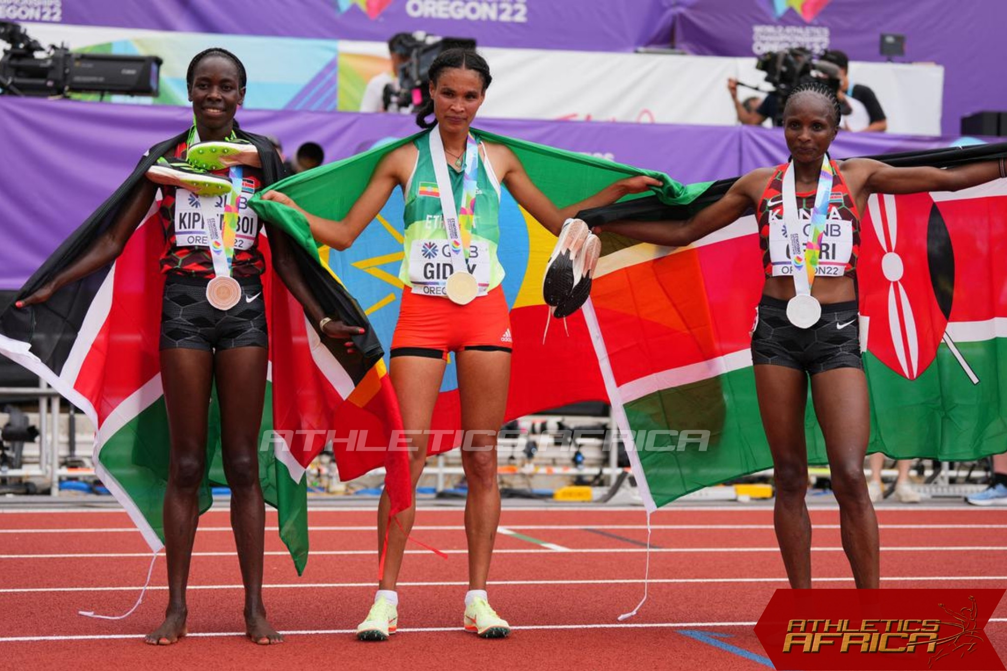 Ethiopia’s Letesenbet Gidey poses with the gold medal after winning the women’s 10,000m final next to silver medallist Kenya’s Hellen Obiri and bronze medallist Kenya’s Margaret Chelimo Kipkemboi / Photo credit: Reuters